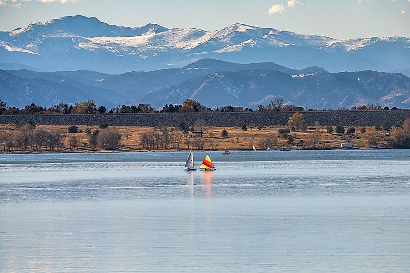 A peaceful Autumn day at Cherry Creek State Park, in Colorado with Sailboats on the lake and the Mountains visible in the background.