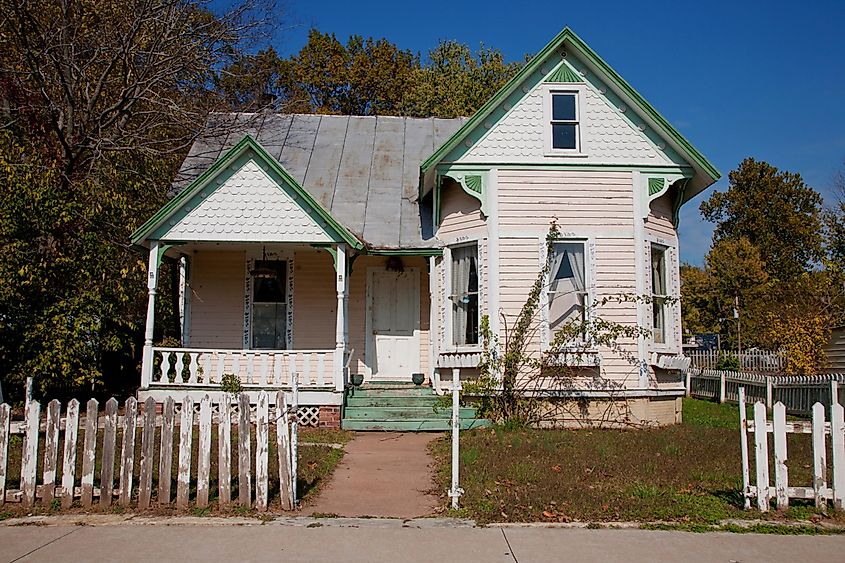 Old Victorian house with a weathered white picket fence in Grafton, Illinois, near the Mississippi River.
