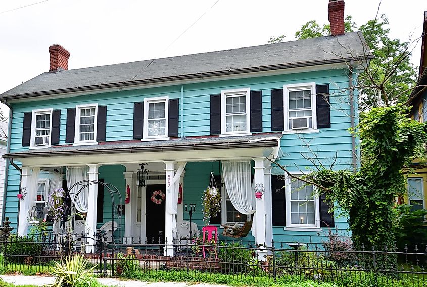 A beautiful newly restored colonial-style home in blue with black shutters stands out in the historical district of downtown Laurel, Delaware, USA.