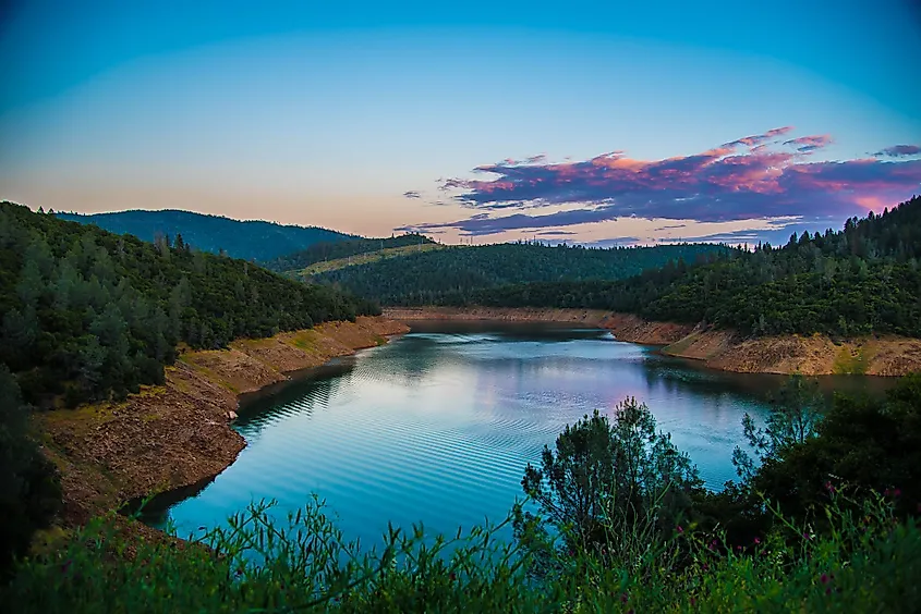 Lake Oroville in California with green hills around a long reservoir shoreline.