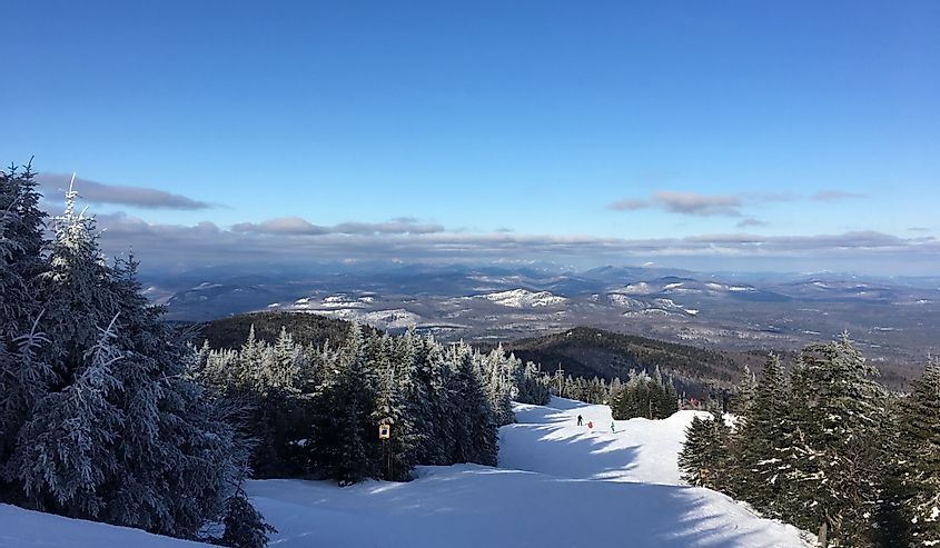 Looking down a ski slope with the Adirondack High Peaks in the background. Gore Mountain, North Creek, New York.