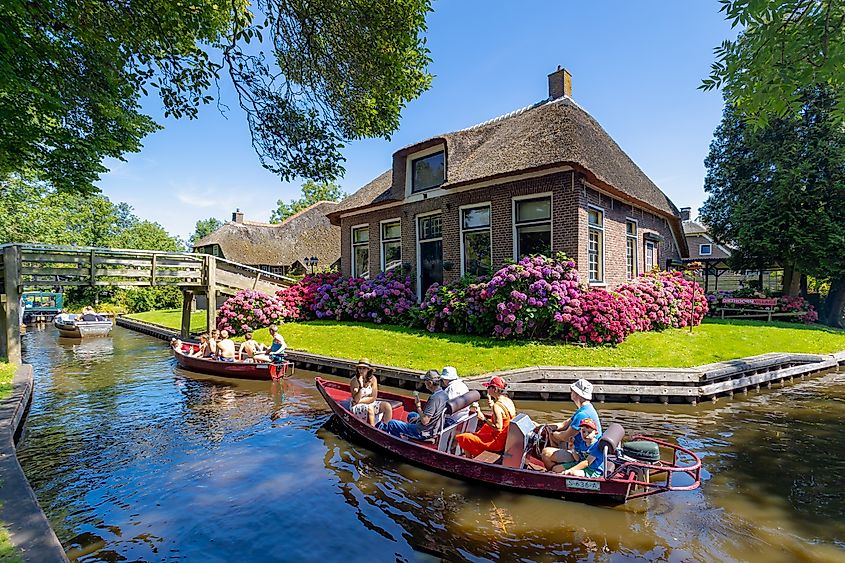Traditional canal houses and summer tourists in Giethoorn, Overijssel, Netherlands, car-free village in Steenwijkerland