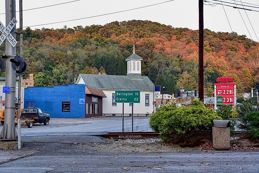 Roadsign pointing towards Belington and Elkins, West Virginia. Railroad tracks are in the foreground.