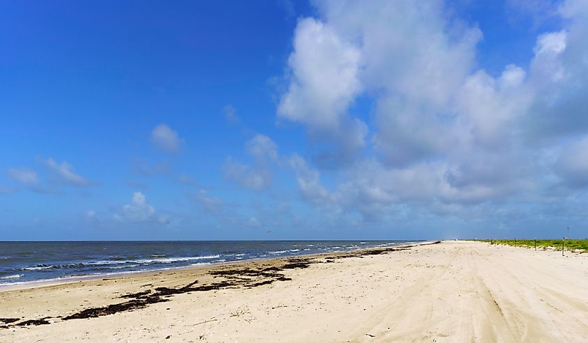 The deserted beach at Rutherford Beach, Cameron Parish, Louisiana, on the Gulf of Mexico, with blue sky and gentle surf.
