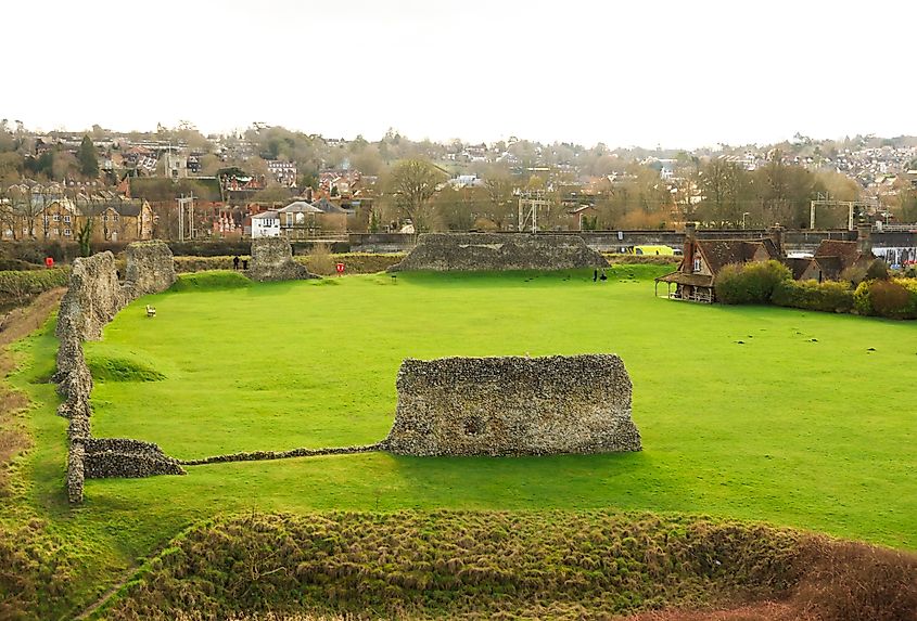 Berkhamsted, England, UK February 14, 2026: Ancient stone walls of Berkhamsted Castle ruins with a green lawn and distant town
