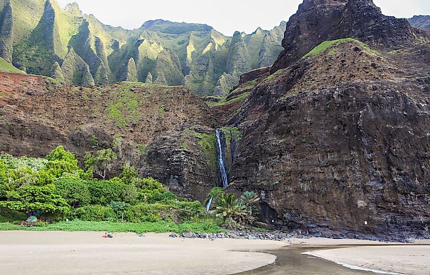 Waterfall coming off the cliff onto the beach at Kalalau on the Napali Coast, the northern shore of Kauai. 
