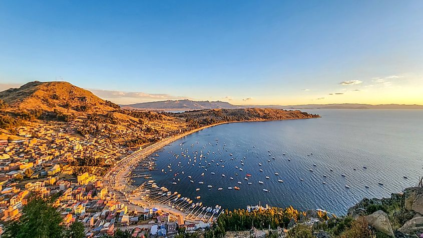 Boats float on Lake Titicaca under the golden light of the Andean highlands.