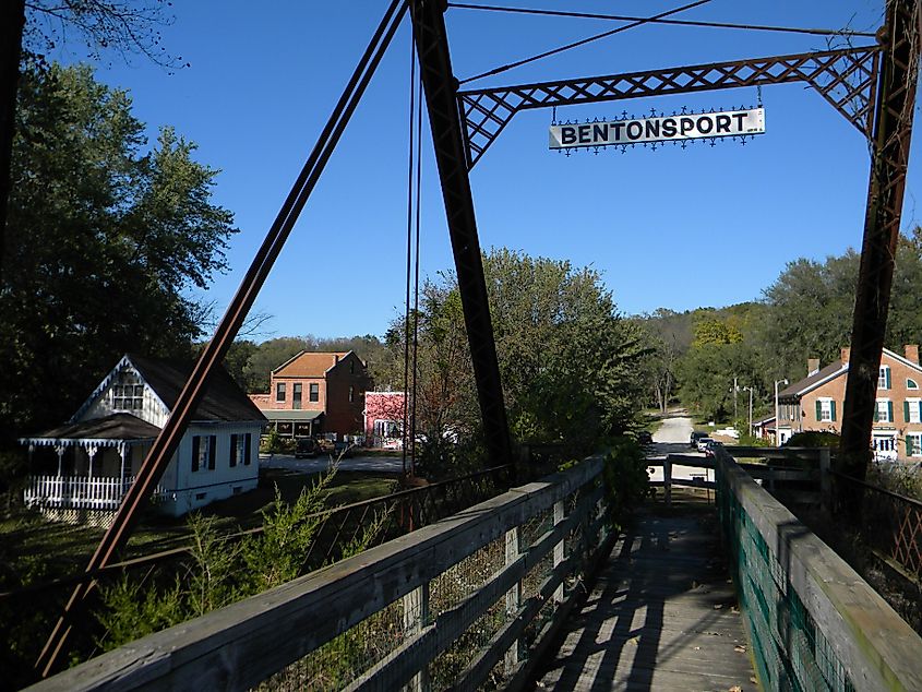 A view from a pedestrian bridge overlooking houses and the natural landscape of Bentonsport, Iowa.