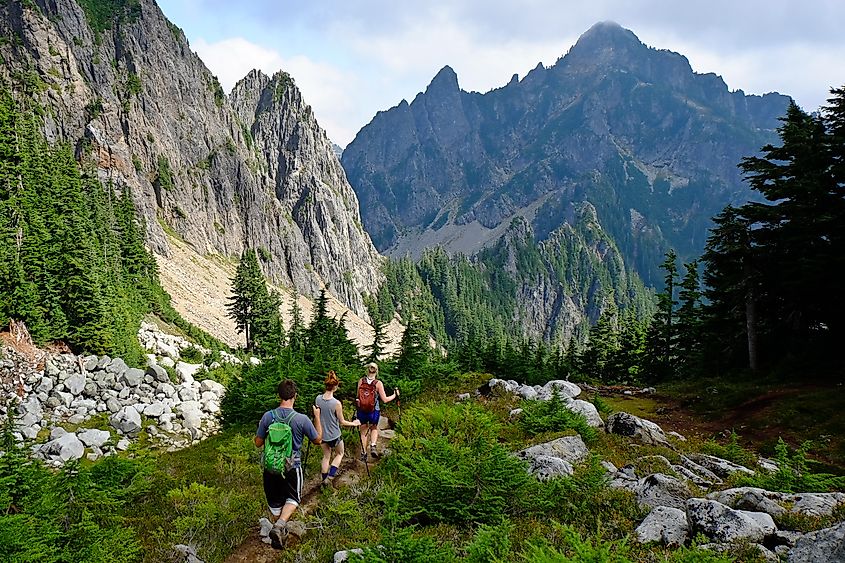 Three Hikers on Mountain Trail in Cascade Mountains. North Cascades, Washington