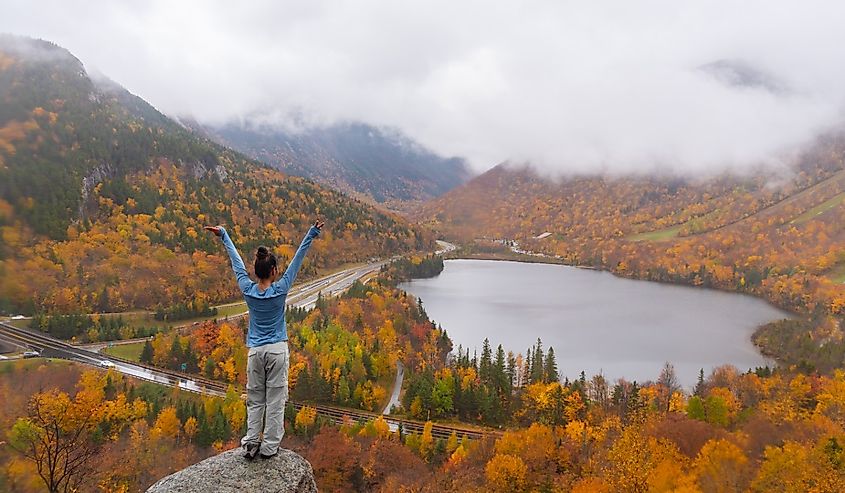 Woman posing in front of beautiful Echo Lake from Artists Bluff Loop in New Hampshire