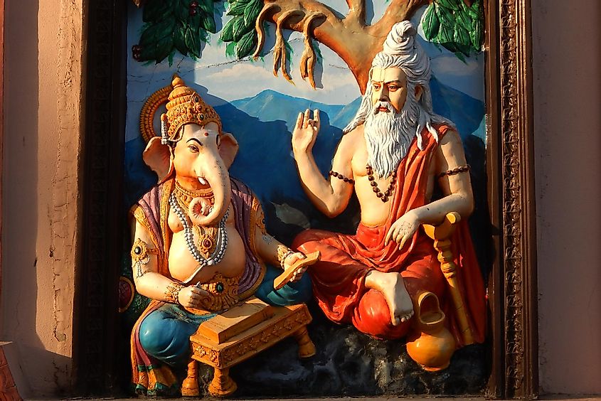 Wall art of Sage Vyasa dictating the story to help God Ganesha to write Hindu epic, via reddees / Shutterstock.com