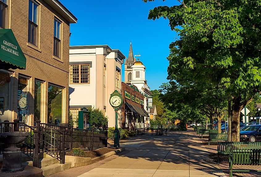 Churches and storefronts along a shaded block of Broadway Avenue in Granville, Ohio.