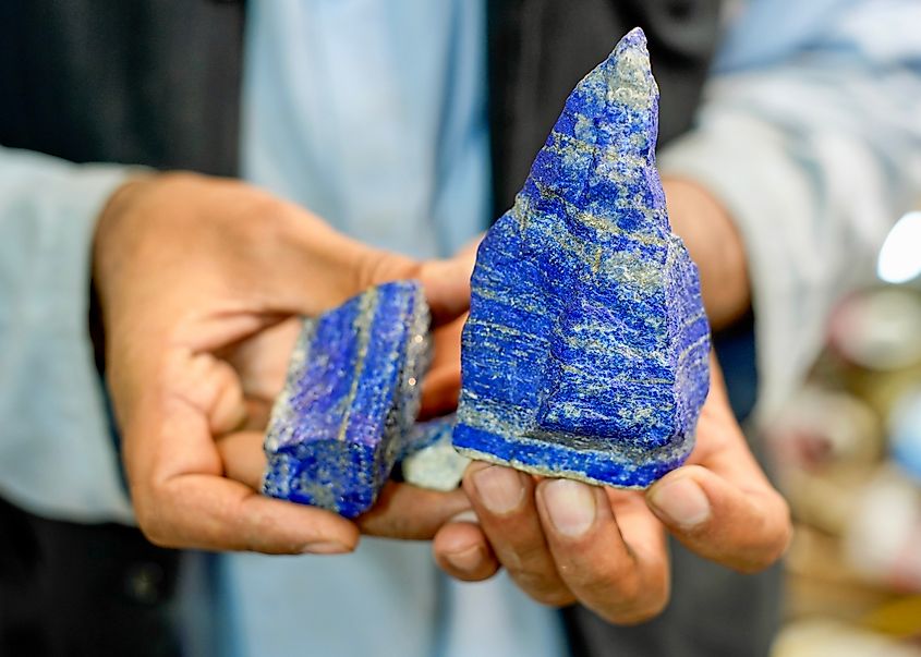 A man holding a rough boulder of lapis lazuli, the deep blue stone found mainly in the Hindu Kush mountains