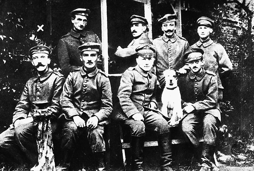 Hitler in his younger days (farthest left at bottom row) posing with other German soldiers and their dog Fuchsl. 
