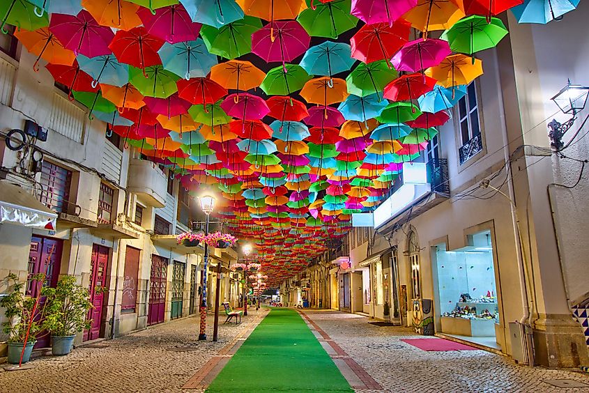 Colorful umbrellas in the street during the Agitágueda street festival in Águeda, Portugal