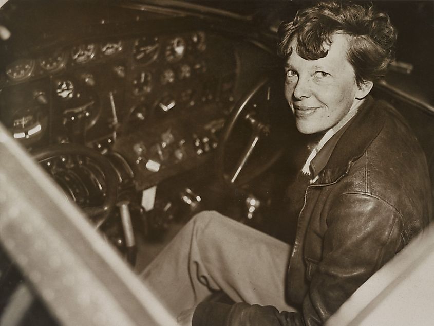 Amelia Earhart sitting in the cockpit of her Lockheed Electra airplane.