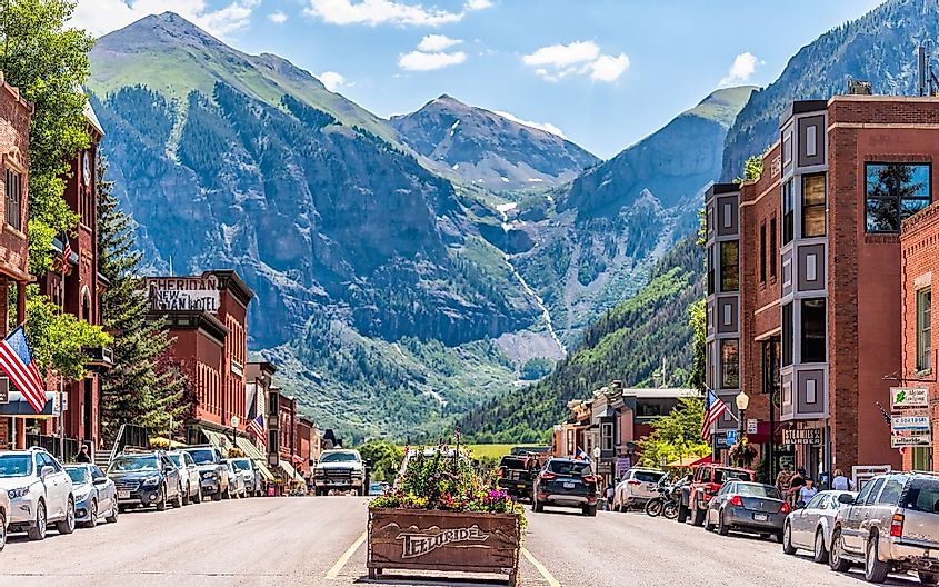 Telluride in Colorado with sign for city and flowers by historic architecture on main street mountain view