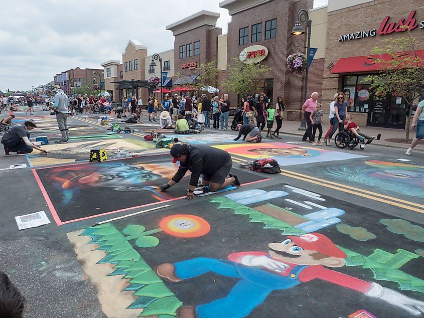 Chalk artists work on their art work in the street, during the city's annual Chalkfest art festival