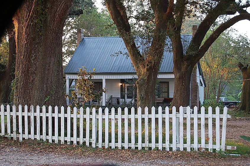Facade of the Dixon House, Prairieville, Louisiana with a white picket fence in front.