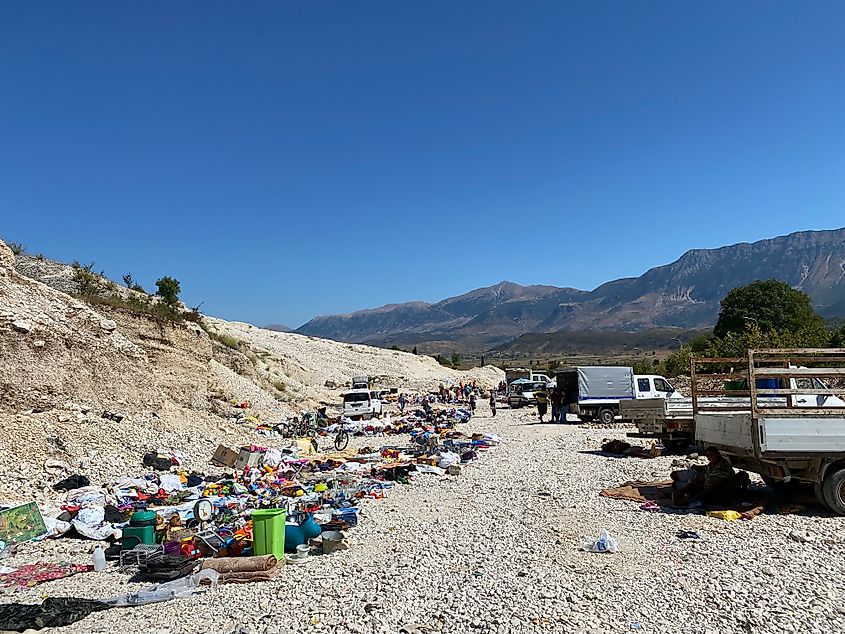 A scrappy flea market spread across a long gravel pit. 