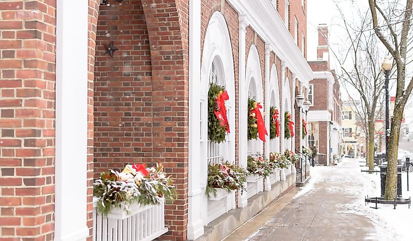 Red bows adorn wreaths hanging in the windows on a quiet, snowy, small-town Mainstreet, Hanover, New Hampshire.