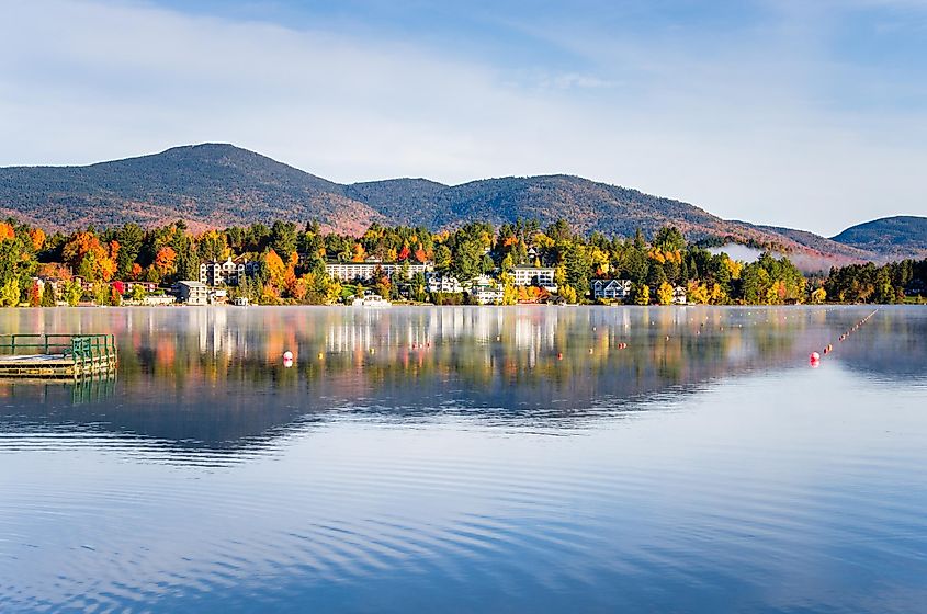 Foggy sunrise over Mirror Lake, Lake Placid mountain village in the background.