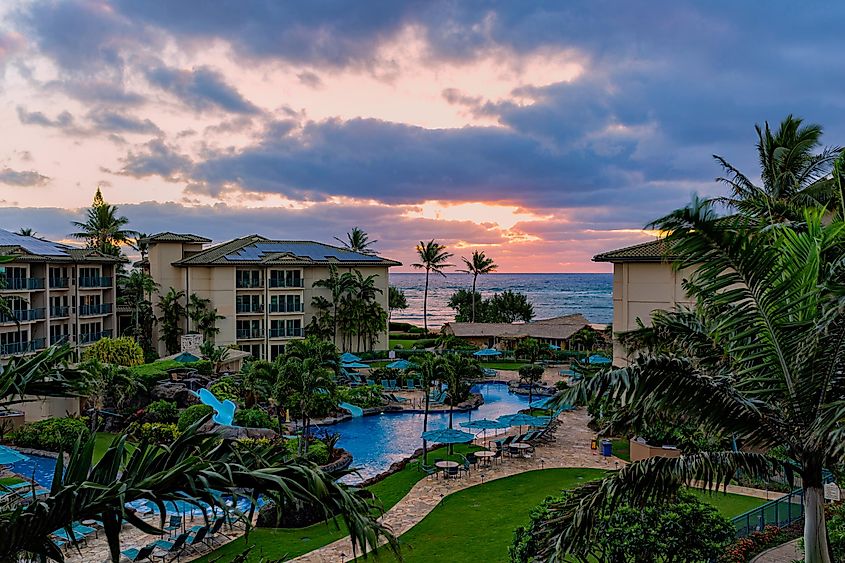 Sunrise over the ocean at a resort at Waipouli Beach with pool in the foreground, via Stan Jones / Shutterstock.com