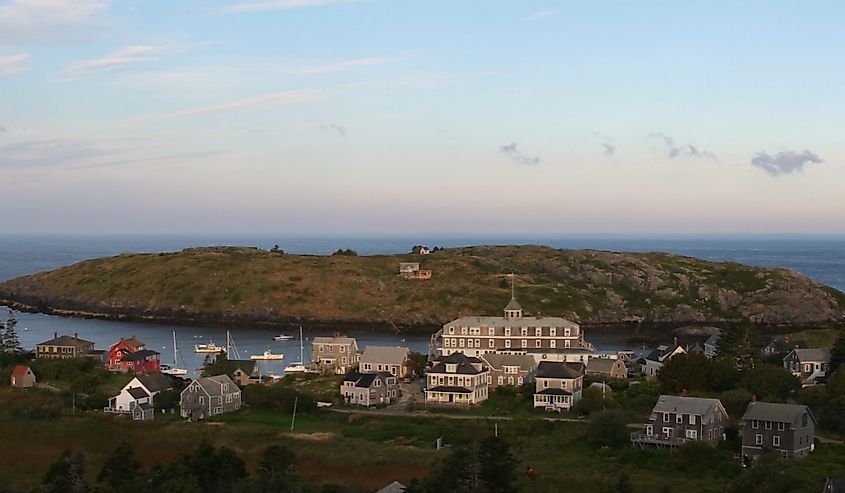 Monhegan Island with homes, surrounded by water at sunrise