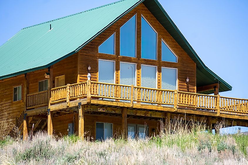 Log cabin with large windows and a walk-out deck in Garden City, straddling the Idaho/Utah border.