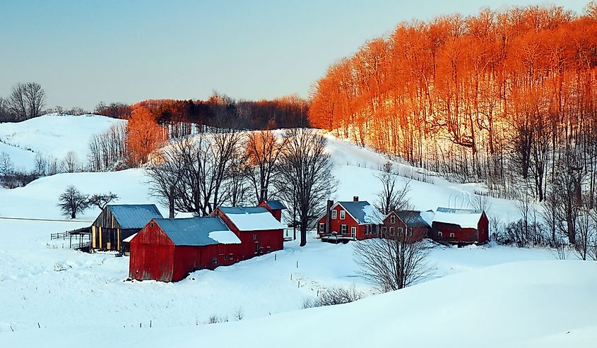 The sun rises for a snowy beginning of the day on a farm near Woodstock, Vermont