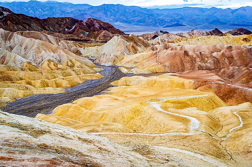 Colorful sunrise over golden brown badlands and Furnace Creek Formation at Zabriskie Point Death Valley.