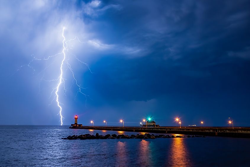 Lightning strikes Lake Superior behind the Duluth North Pier Lighthouse in Canal Park, Minnesota. Credit: Isaac Reinlieb/Shutterstock.com