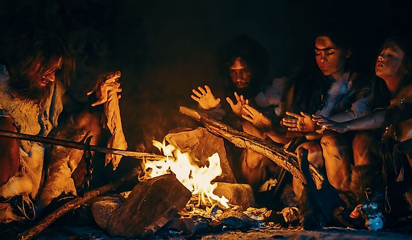 Early humans huddle around a fire for warmth. 