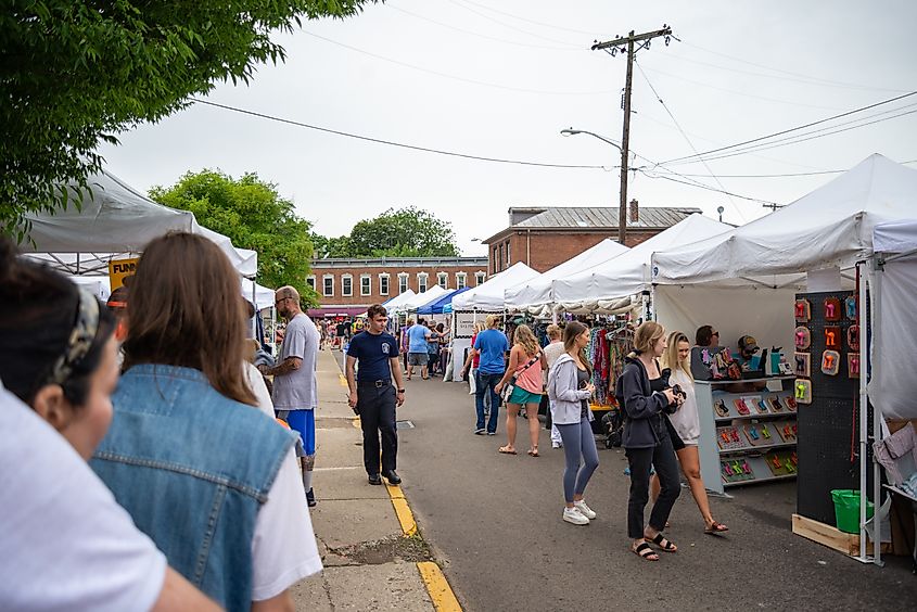 People shopping and browsing vendor booths at a lively public street fair in Yellow Springs, Ohio