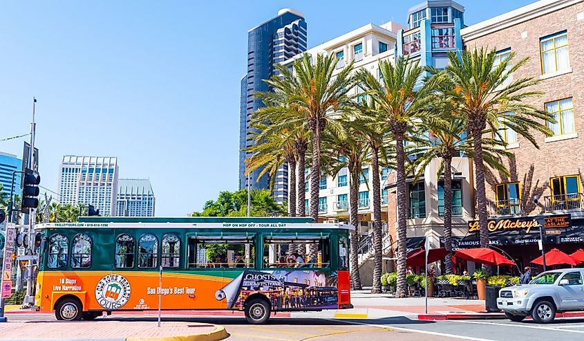 Off Tour Bus with tourists taking a ride in the Gaslamp Quarter district in traffic on the city streets of sunny San Diego, California.