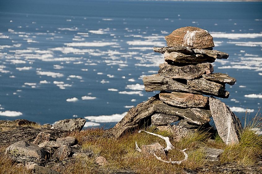 An ancient Inuit inukshuk serves as a landmark for seafarers in a fjord of Baffin Island, Nunavut, Canada.