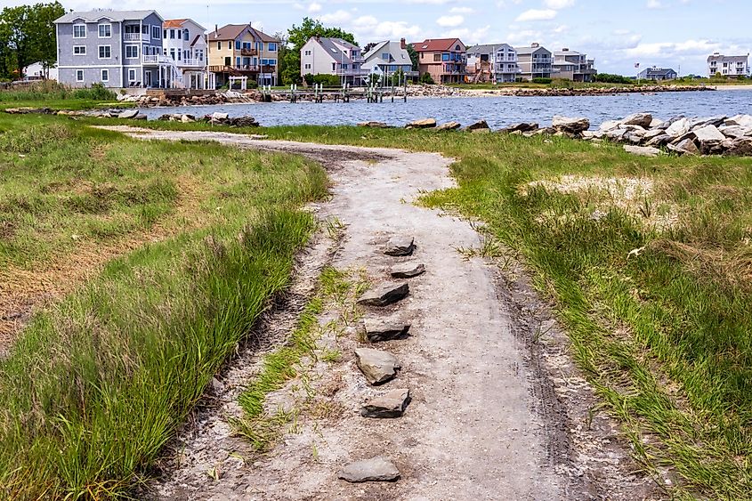 Coastal gravel road with the small seaside neighborhood on the background in East Greenwich, Rhode Island