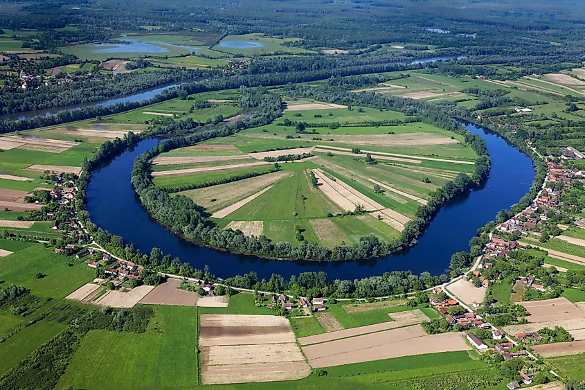 An oxbow lake curving beside a meandering river.