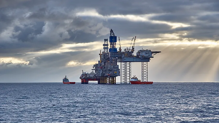 An offshore platform and support vessels in the North Sea under heavy cloud.