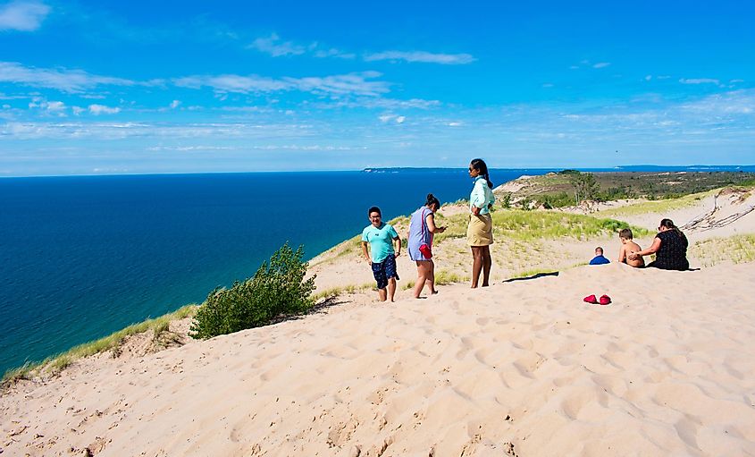 Tourists and Campers on Lake Michigan Overlook in Sleeping Bear Dunes National Lake-shore, Empire, via Paper and Lens Co / Shutterstock.com