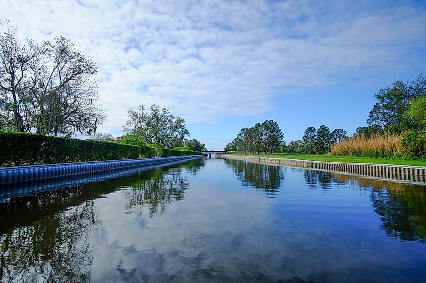 Calm canal in Winter Haven, Florida, lined with trees and grassy banks.
