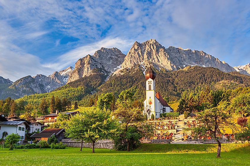 Garmisch Partenkirchen Germany, Zugspitze peak and Alps mountain range with small church in Grainau village. 
