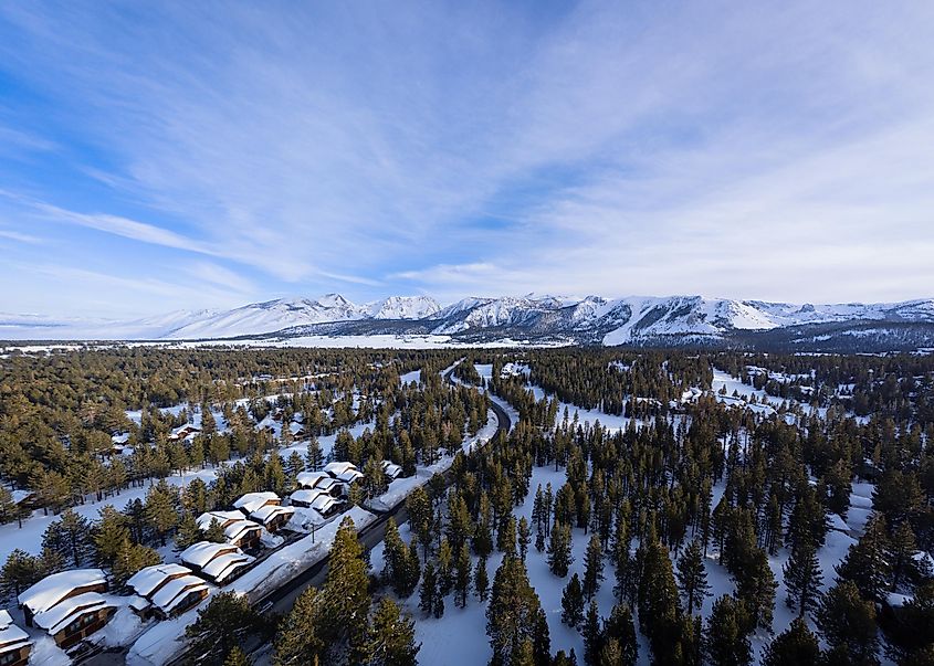 Aerial view of Mammoth Lakes, California, during winter, with snowy mountains in the background.