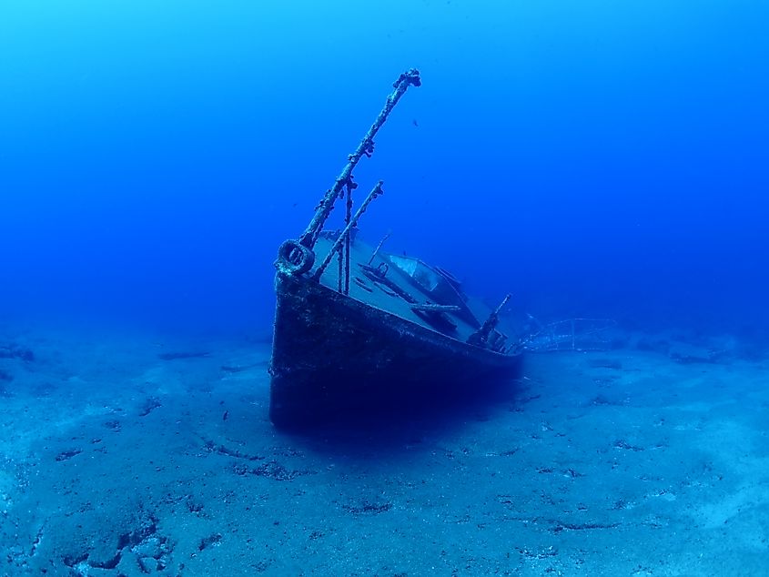 Underwater shipwreck on sea floor.