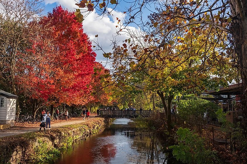 Visitors walk the paths of the Delaware Canal Trail during a warm fall day as the trees show their autumn foliage in Lambertville, New Jersey, USA.