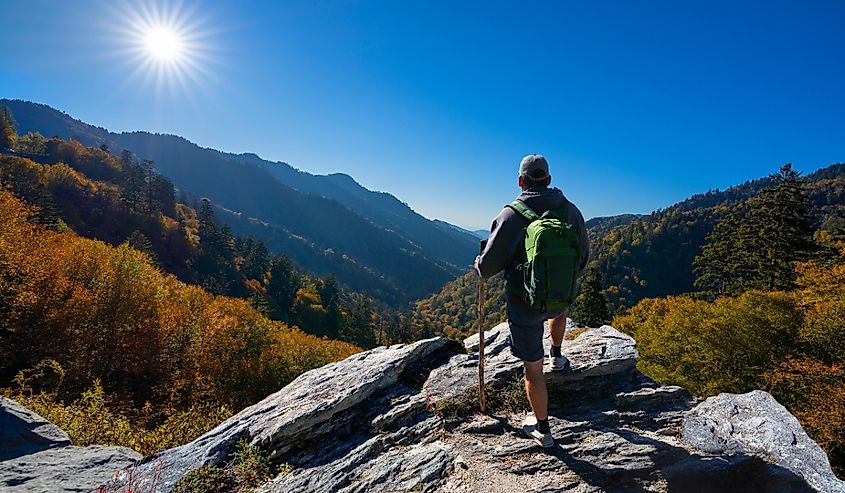 Man hiker standing on top of the mountain enjoying beautiful fall scenery. Smoky Mountains National Park, near Gatlinburg, Tennessee