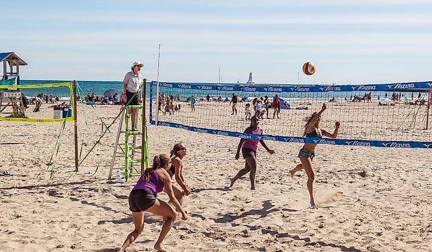 Four women playing beach volleyball at Victoria Beach in Cobourg, Ontario