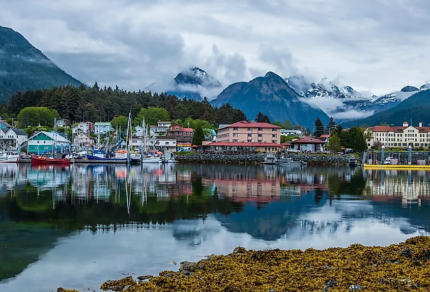 The waterfront of Sitka, Alaska, with mountains rising behind the harbor.
