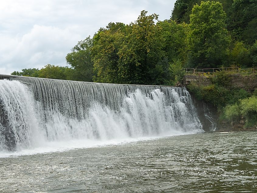 Mist rises from a Weir waterfall on the Root River in Lanesboro, Minnesota on a cloudy day.