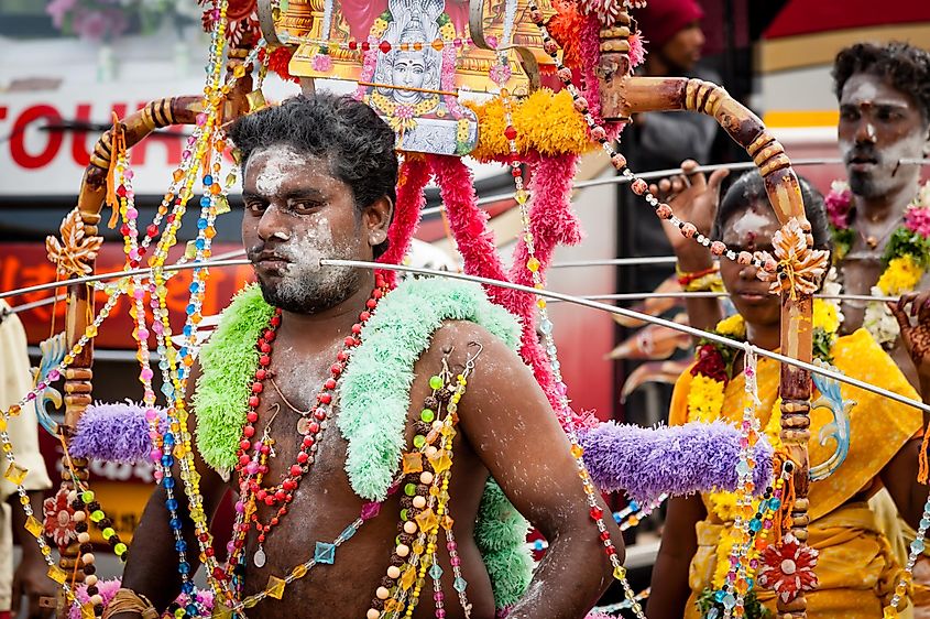 A devotee with cheek piercings carries a kavadi during Thaipusam